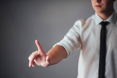 İşadamı, stüdyodaki siyah arka planda boş bir yeri işaret ediyor.