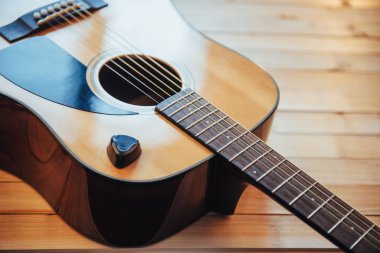 Açık kahverengi arkaplanda klasik gitar.