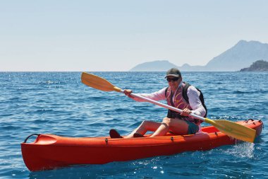 Güneşli bir günde kayalıkların yanında kayık gezintisi. Seyahat, spor konsepti. Yaşam biçimi.