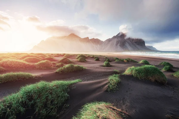 Fantastic west of the mountains and volcanic lava sand dunes on the beach Stokksness, Iceland.