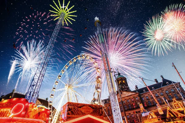 amusement park at the center of Amsterdam at night. Beautiful starry sky, majestic fireworks on the nightlife.