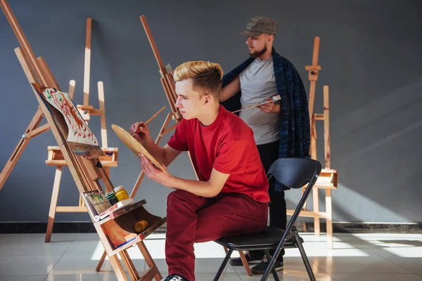 Artists paint pictures in the studio. Creative artists have designed a colorful picture painted on canvas with oil paints in the studio.