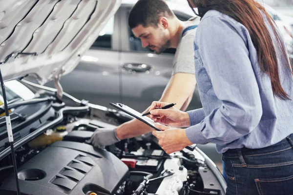 Ein Mechaniker Und Eine Kundin Schauen Sich Die Motorhaube Und — Stockfoto