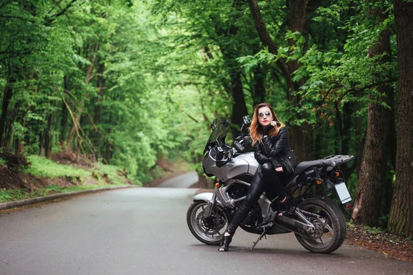 魅力的なセクシー女の子服を着た革のポーズ近くにAスポーツバイク外 — ストック写真