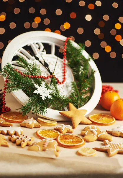 Happy New Year at midnight 2018, Old wooden clock with holiday lights and fir branches. Cooking and decorating christmas gingerbread cookies and fried orange slices — Stock Photo, Image