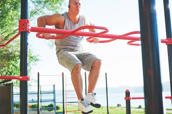 Homem Musculoso Com Belo Tronco Exercitando Barras Horizontais Fundo Parque — Fotografia de Stock