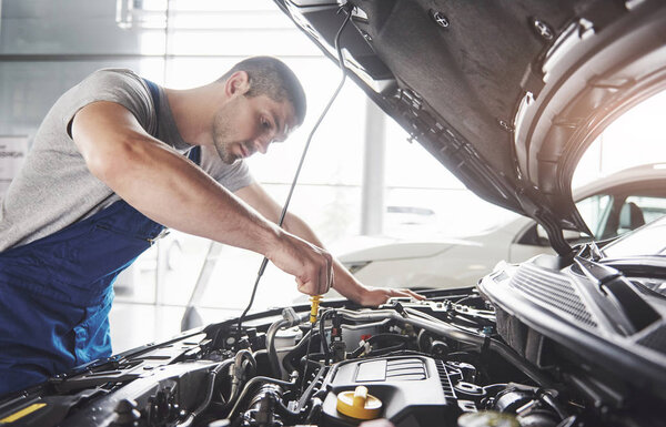 Picture showing muscular car service worker repairing vehicle.