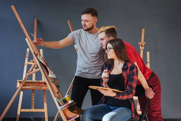 Artists paint pictures in the studio. Creative artists have designed a colorful picture painted on canvas with oil paints in the studio.