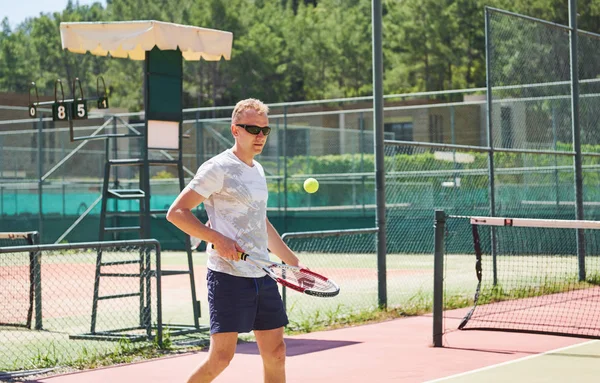 Man playing tennis. Summer sport, beautiful resort