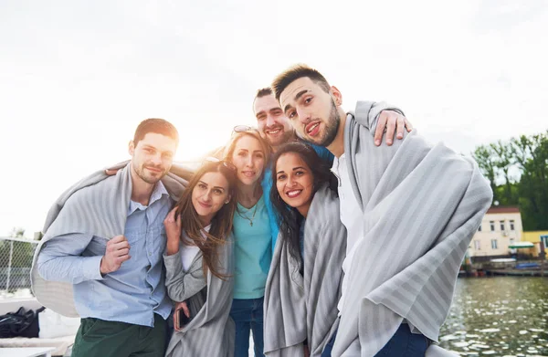 Smiling happy group of friends posing for the camera outdoors on the beach pier — Stock Photo, Image