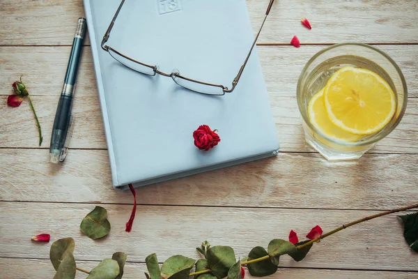 Büchergläser Und Blütenblätter Und Ein Glas Wasser Mit Zitrone — Stockfoto