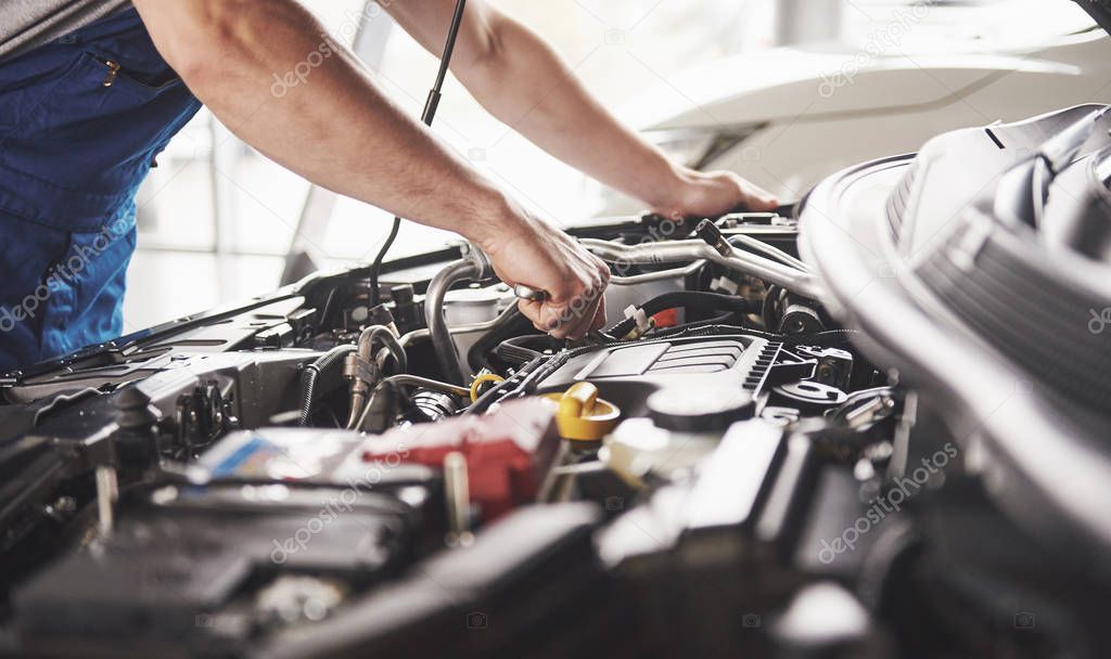 Auto mechanic working in garage. Repair service.