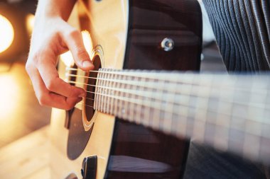Gitarist gitar üzerinde ahşap arka plan çalış, yakın çekim.