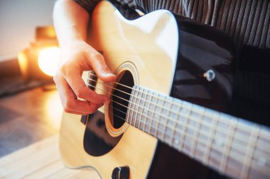 Gitarist gitar üzerinde ahşap arka plan çalış, yakın çekim.