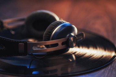 Plaklar ve kulaklıklar ahşap masanın üzerinde. Ses meraklısı, müzik aşığı veya profesyonel disk jokey ekipmanı