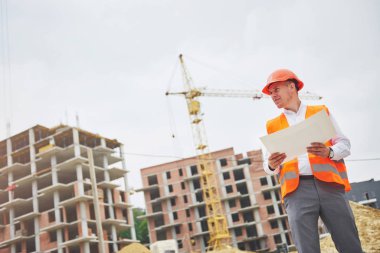 mimari ve ev yenileme kavramı - blueprint Fabrikası ile eldiven ve kask içinde adam.