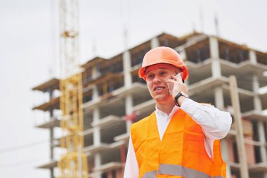 Koruyucu Kask ayakta açık arka bina dağlar giymiş genç mimar.