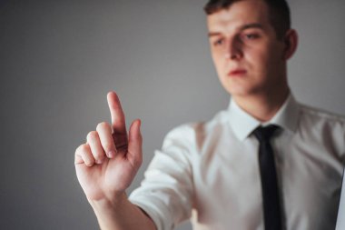 İşadamı, stüdyodaki siyah arka planda boş bir yeri işaret ediyor.