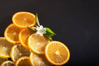 Siyah arka planda izole edilmiş portakal ve limon dilimleri..