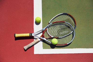 Tenis raketi ve yeni boyanmış tenis kortunda yeni bir tenis topu..