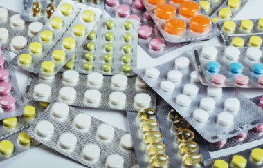 Mühürlü bir paket yüzey üzerinde farklı renkteki hapları yalan