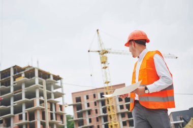 mimari ve ev yenileme kavramı - blueprint Fabrikası ile eldiven ve kask içinde adam.