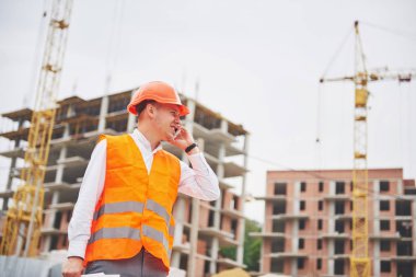 Koruyucu Kask ayakta açık arka bina dağlar giymiş genç mimar.