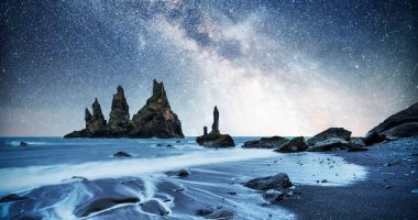 The Rock Troll Toes. Reynisdrangar cliffs. Black sand beach. Iceland. Fantastic starry sky and the milky way. clipart