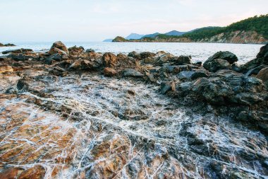 Kıyı boyunca büyük kayalar, kayalıklar ve kayalar. Keskin taşlar duvar kağıdı.