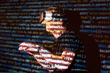 Kafkasyalı bir adam ve Sanal gerçeklik kulaklığının çifte pozlandırılması muhtemelen kod satırları olan güvenli bir ağ ya da sunucuya şifreyi kıran bir oyuncu ya da hackerdır.