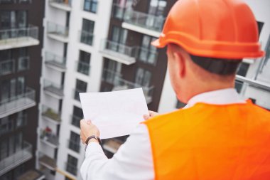 Koruyucu Kask ayakta açık arka bina dağlar giymiş genç mimar.