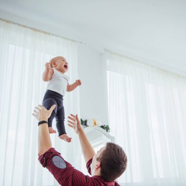 Father throwing hand high air joyful daughter. The concept of a friendly family.