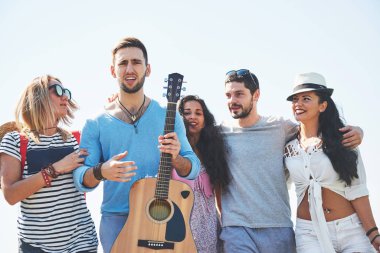 Sahilde olacak arkadaşlar grup portresi. Karışık grup arkadaşıyla sahilde yaz gününde yürüyüş.