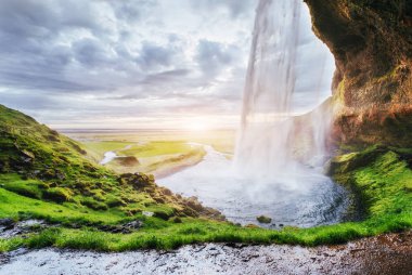 Gün batımında Seljalandfoss şelale. Nehri üzerinde köprü. Muhteşem doğa. İzlanda. Europe