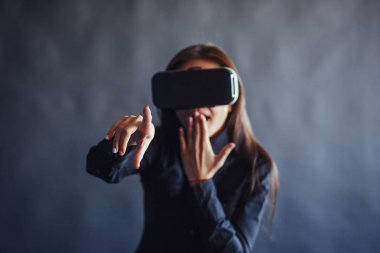 Stüdyoda siyah bir arka plan üzerinde Mutlu kadın Vr-gözlük sanal gerçeklik kulaklık kullanma deneyimi alır