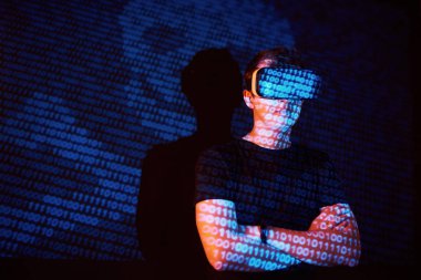 Kafkasyalı bir adam ve Sanal gerçeklik kulaklığının çifte pozlandırılması muhtemelen kod satırları olan güvenli bir ağ ya da sunucuya şifreyi kıran bir oyuncu ya da hackerdır.