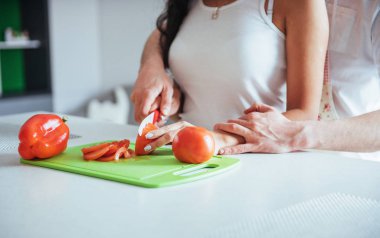 Genç ve güzel bir çift mutfakta sebze öğütüyor.