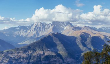 Güzel kümülüs bulutlarında kar kaplı fantastik dağlar..