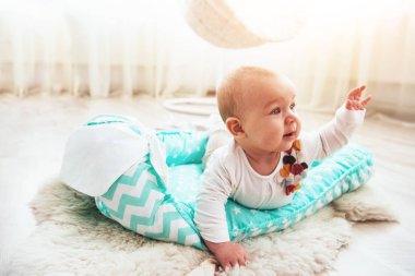 Yatakta altı ay güzel bir kız. İyi ışık stüdyosunda.