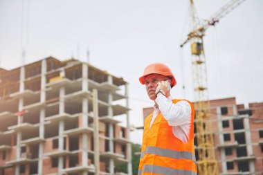 Koruyucu Kask ayakta açık arka bina dağlar giymiş genç mimar.