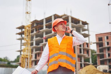 Koruyucu Kask ayakta açık arka bina dağlar giymiş genç mimar.