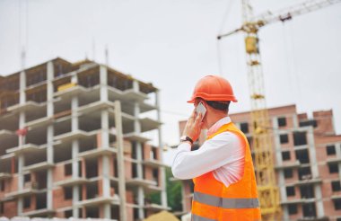 Koruyucu Kask ayakta açık arka bina dağlar giymiş genç mimar.