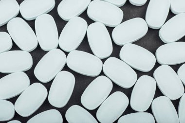 Siyah arka planda tedavi ve sağlık hizmetleri için tıbbi beyaz haplar veya takviyeler.