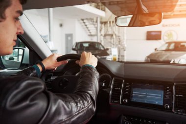 Genç adam kuaförde yeni araba kullanıyor..