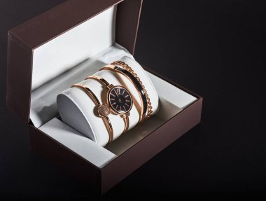 Beyaz bir arka planda altın kadın kol saati.