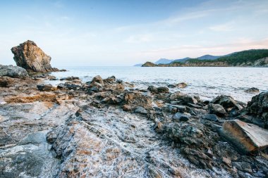 Kıyı boyunca büyük kayalar, kayalıklar ve kayalar. Keskin taşlar duvar kağıdı.