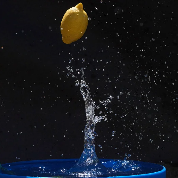 Soczysty Żółty Cytryna Spada Wody Czarnym Tle — Zdjęcie stockowe