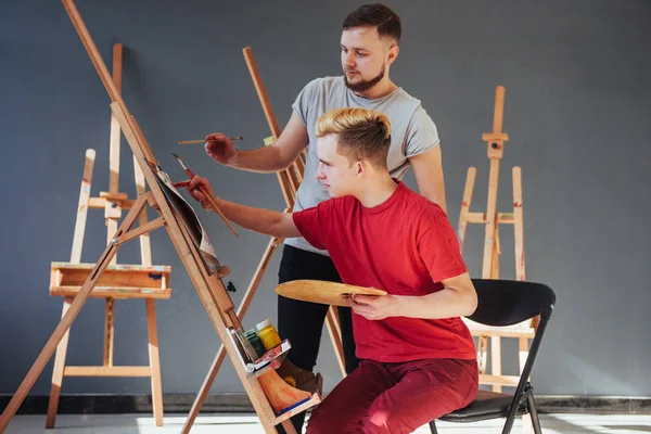 Artists paint pictures in the studio. Creative artists have designed a colorful picture painted on canvas with oil paints in the studio.