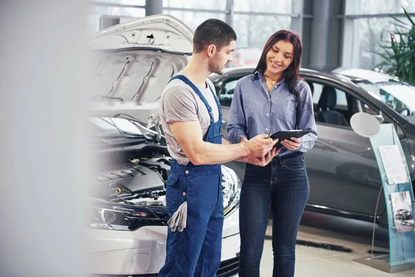 Schöne Junge Frau Spricht Mit Hübschem Automechaniker Während Sie Ein — Stockfoto