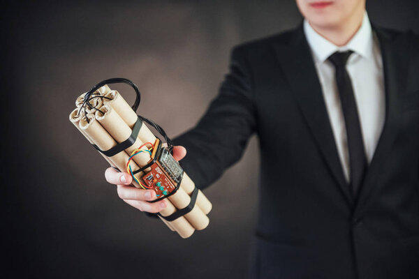 Человек-террорист в черном костюме со взрывчаткой и детонаторами
.